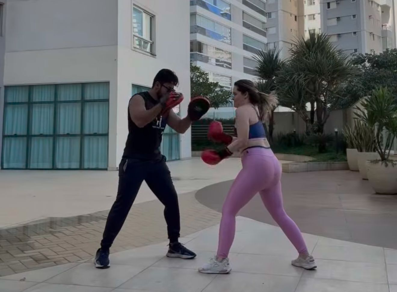 O personal fight Hygor Johnson atende alunos de forma personalizada, inclusive com aulas em domicílio. Na foto, ele chega para mais um treino com a jornalista Fernanda Cappellesso, que encontrou na luta uma aliada para o emagrecimento, o controle da ansiedade e o fortalecimento da saúde mental.