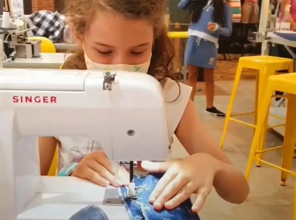 Roupa de boneca ou vestido sob medida? Crianças aprendem costura nas férias no Clube de Costura, em Goiânia